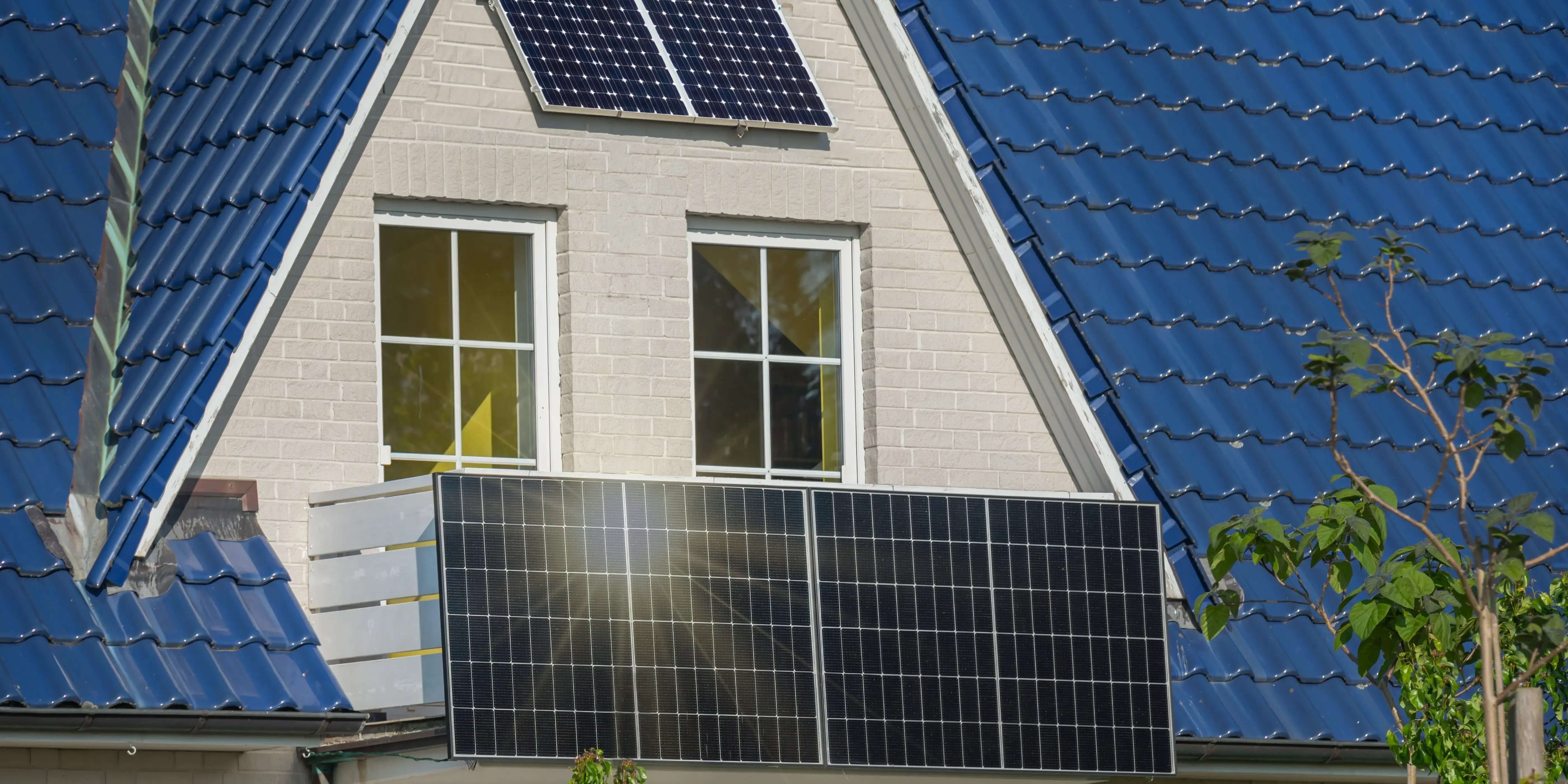 Fachada de casa moderna con paneles solares en el balcón