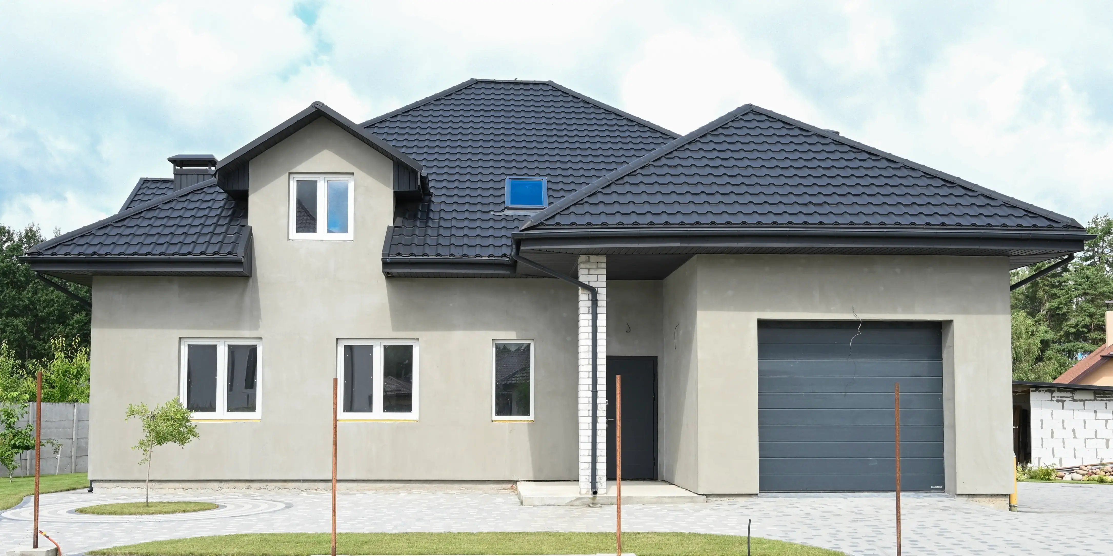 Fachada de casa moderna con paredes gris oscuro y techo negro