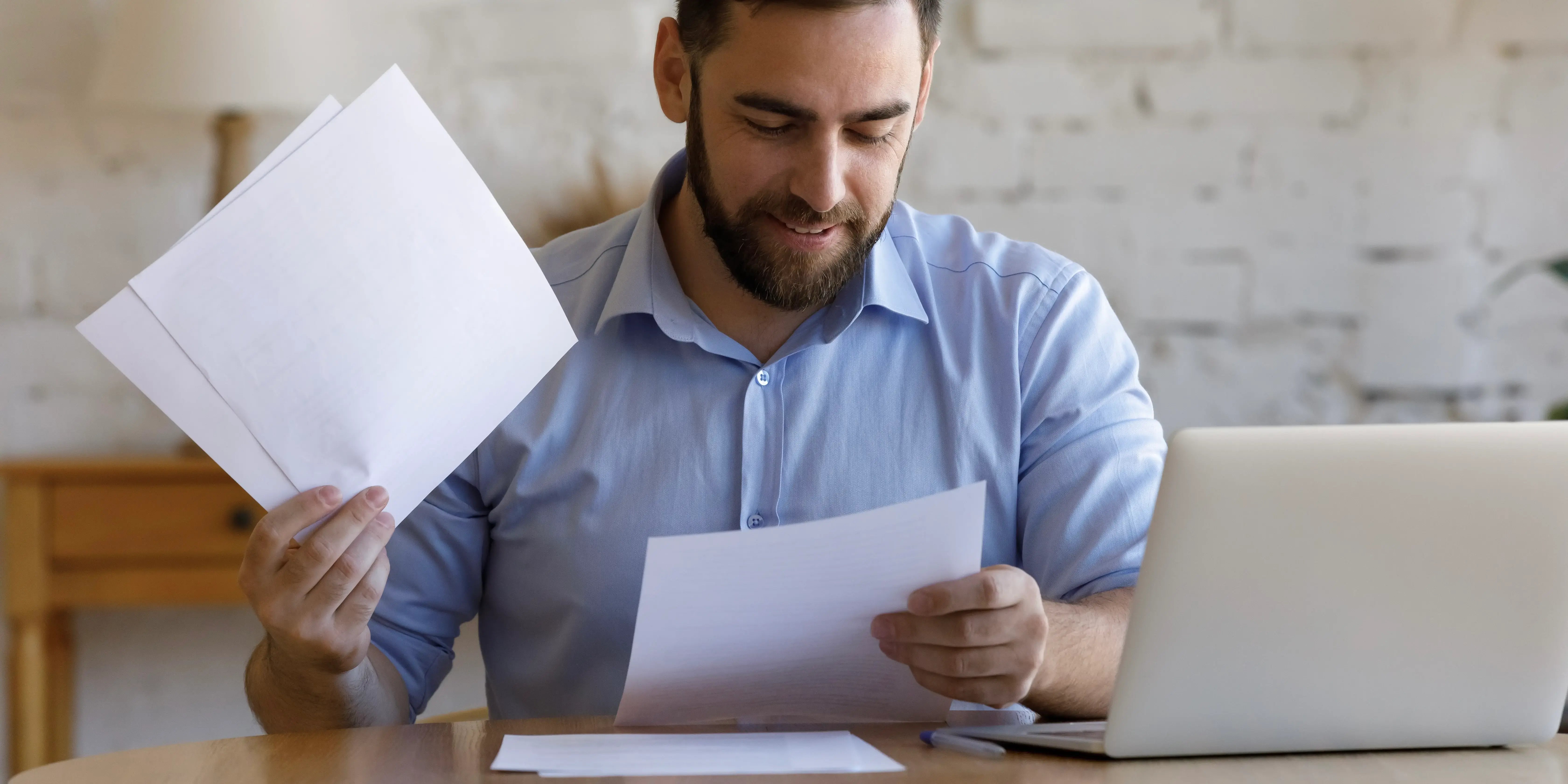 Hombre sosnriente leyendo contrato de una alternativa para comprar casa sin crédito Infonavit