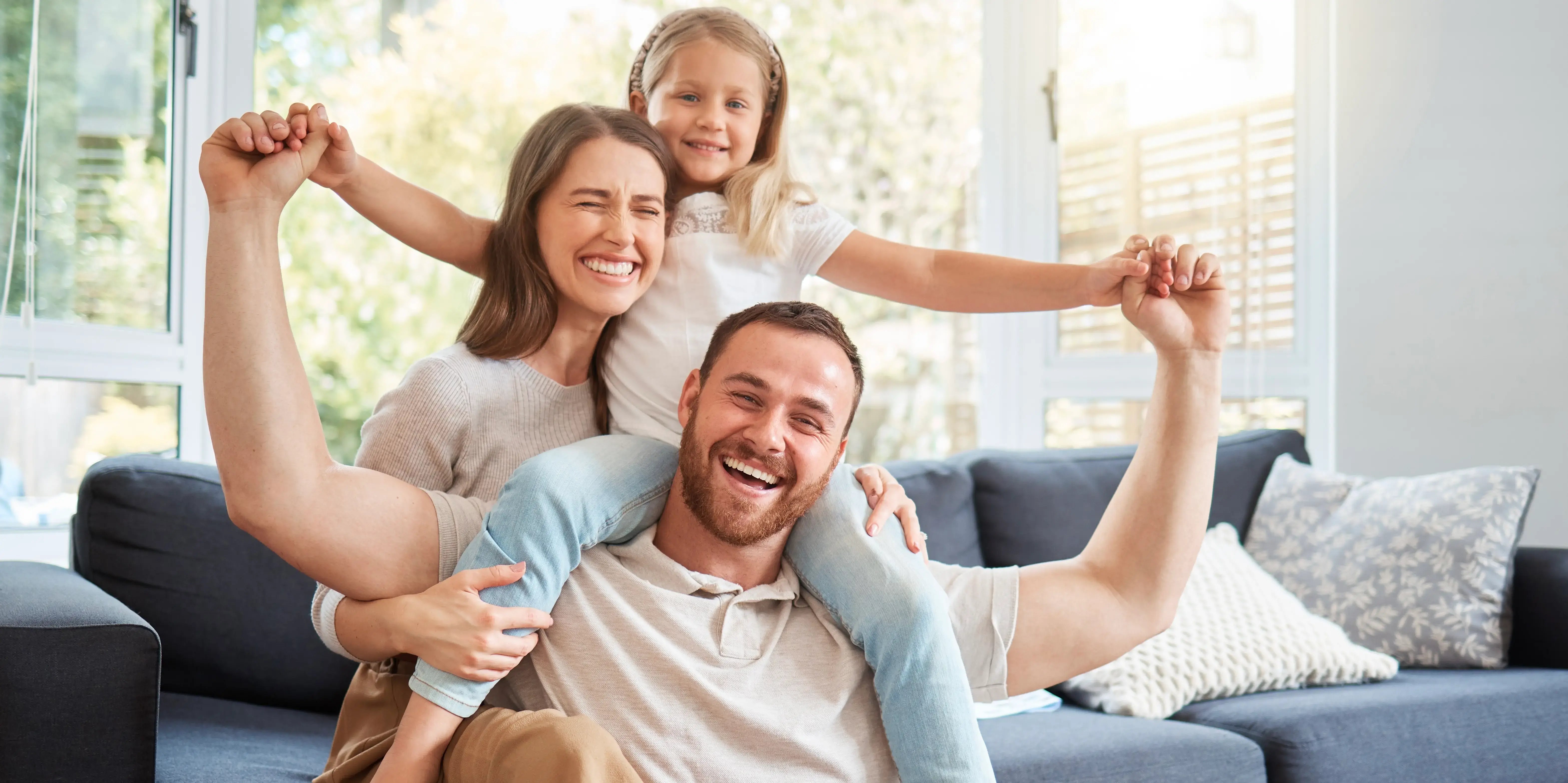 Mamá, hija y papá feliz en la sala de su casa y protegiendo a su familia por tener estabilidad financiera