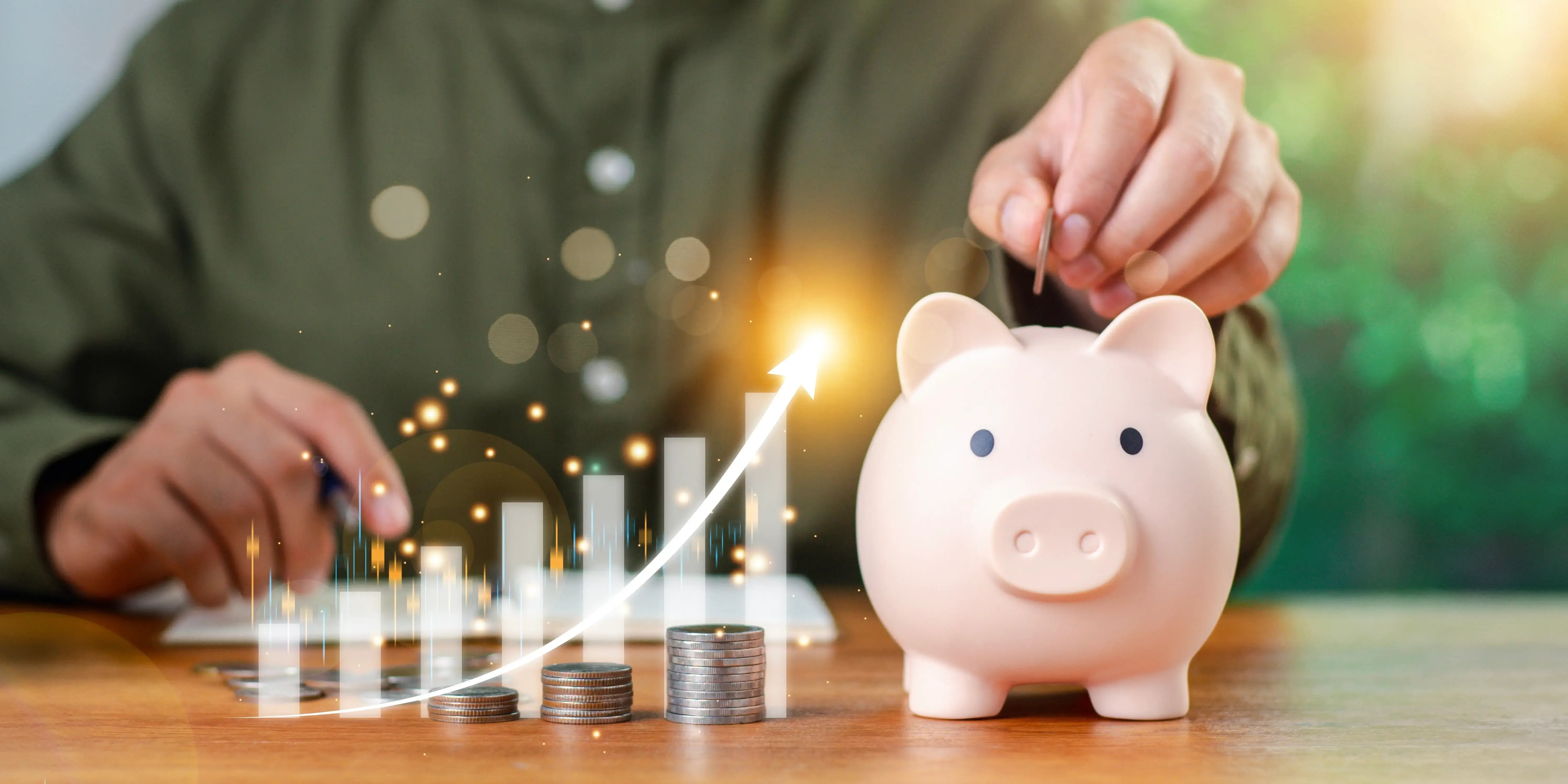 Mano de hombre que pone monedas en la alcancía para empezar su plan de presupuesto personal y cumplir su meta de ahorrar