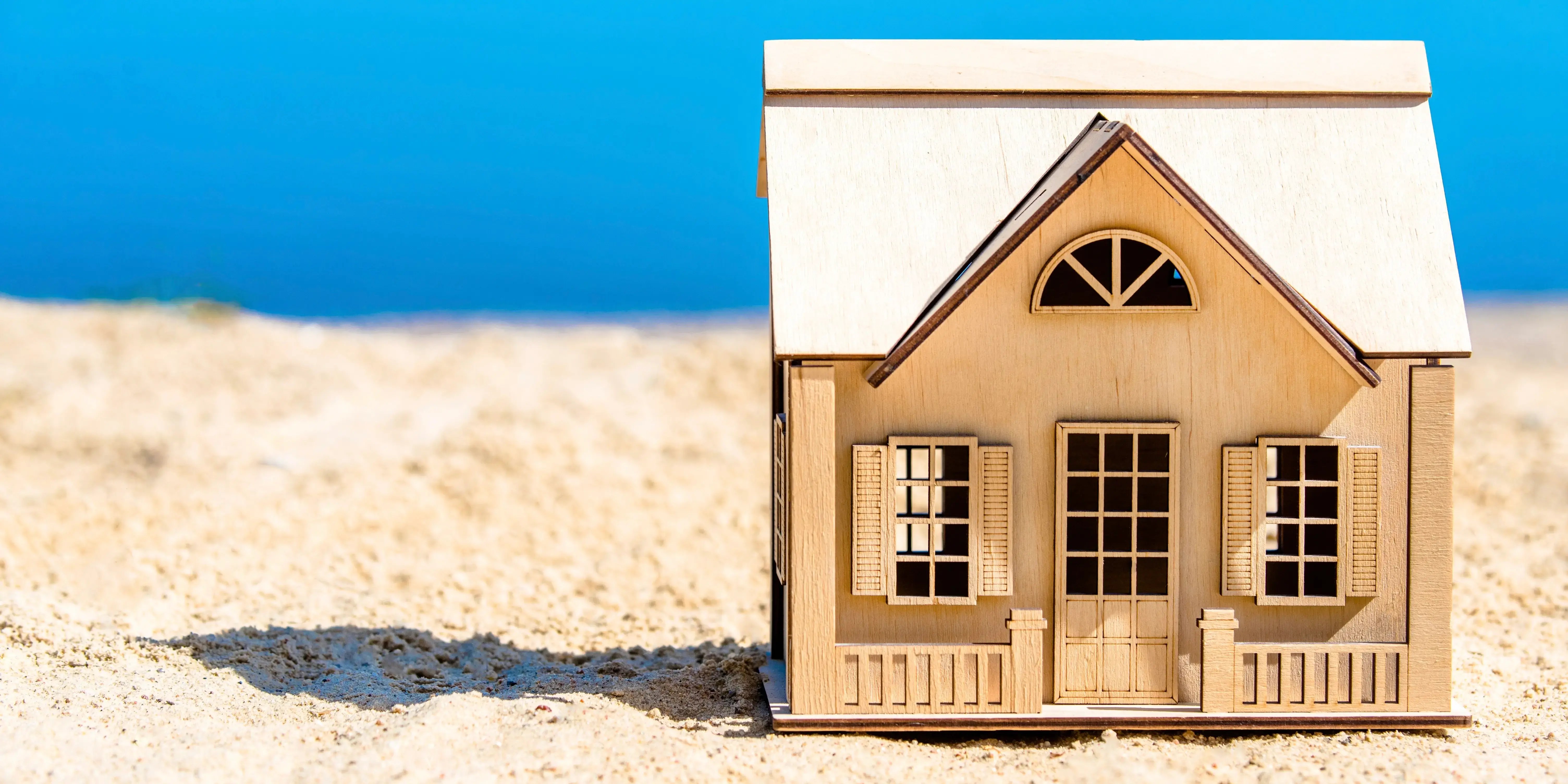 Maqueta de casa de madera a la orilla del mar para aprovechar las promociones inmobiliarias