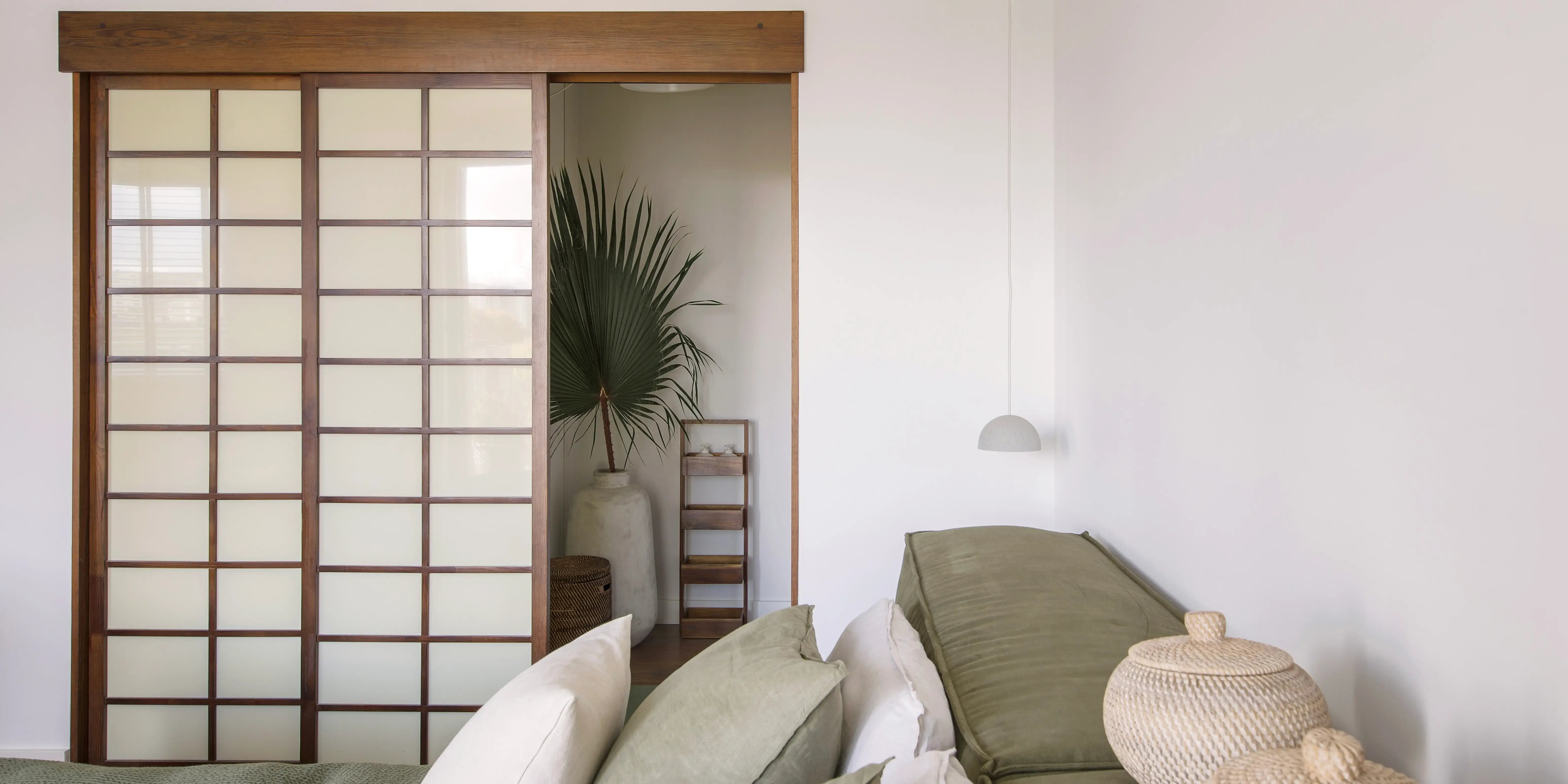 Moderno diseño de interiores estilo Japandi de una habitación en tonos tierra, separando el pasillo con paneles de madera