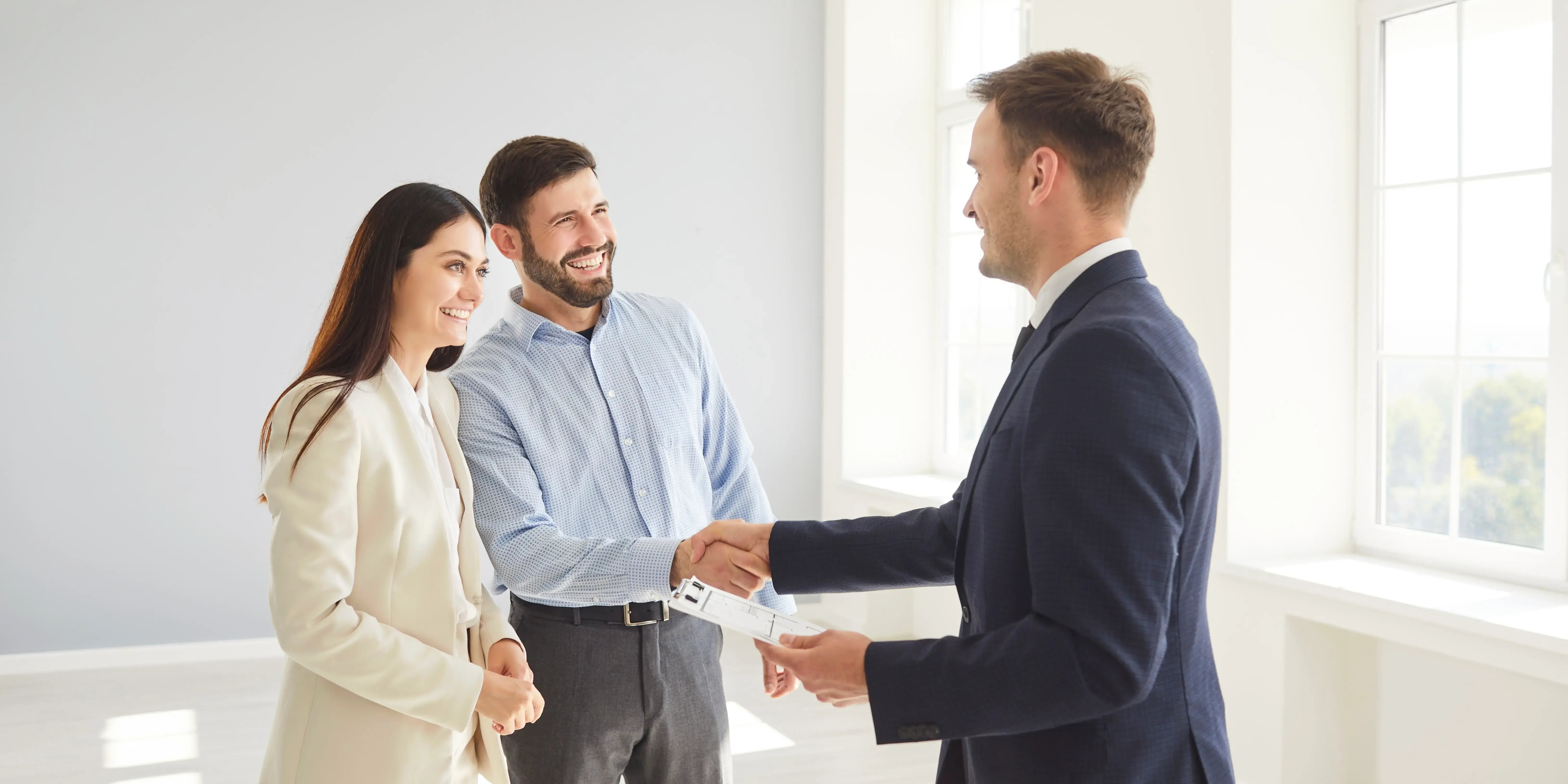 Pareja estrechando mano de experto hipotecario que les explicó como obtener un crédito FOVISSSTE en pareja