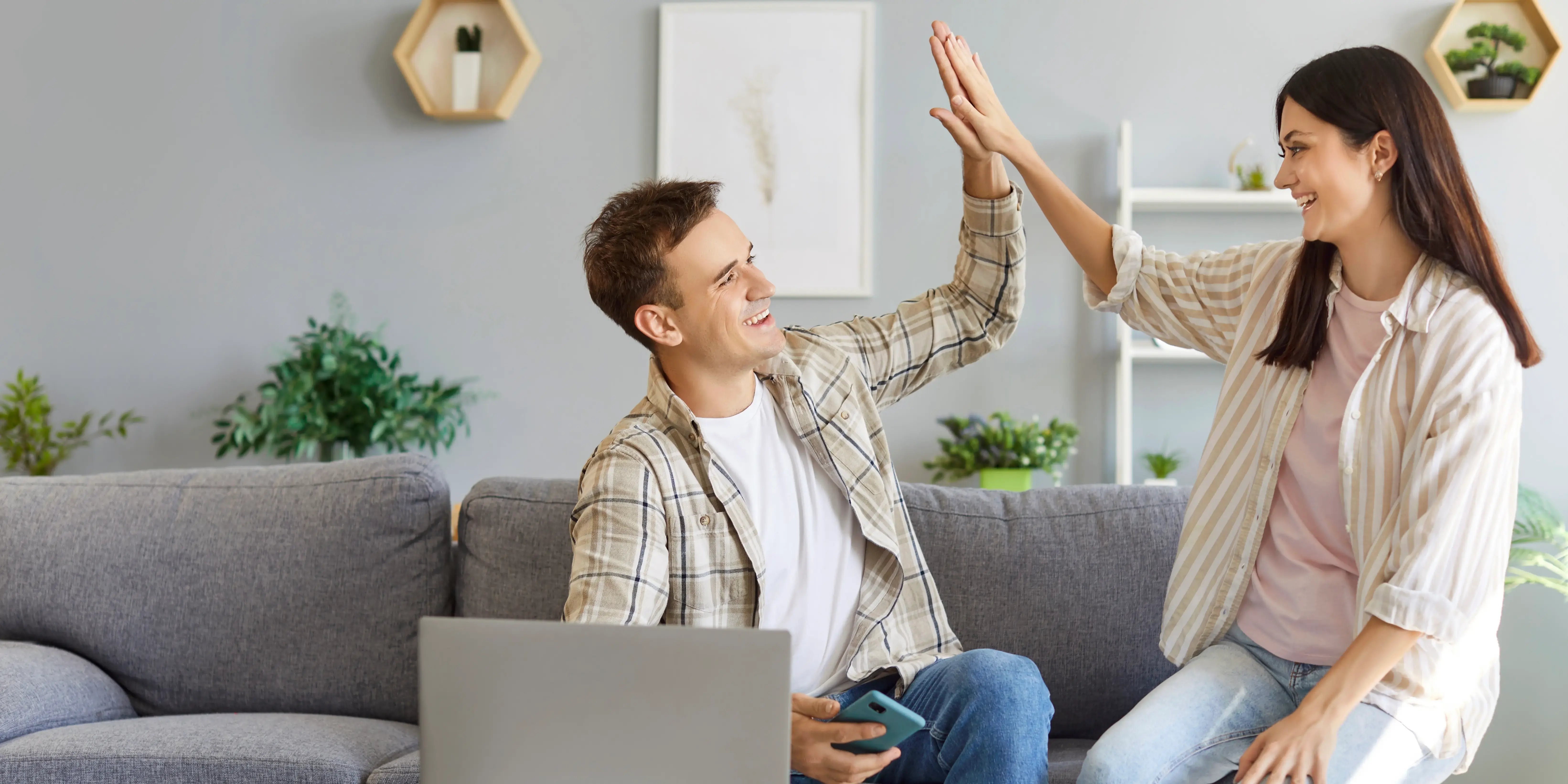 Pareja feliz estrechando las manos pues acaban de unir sus créditos FOVISSSTE para comprar su casa