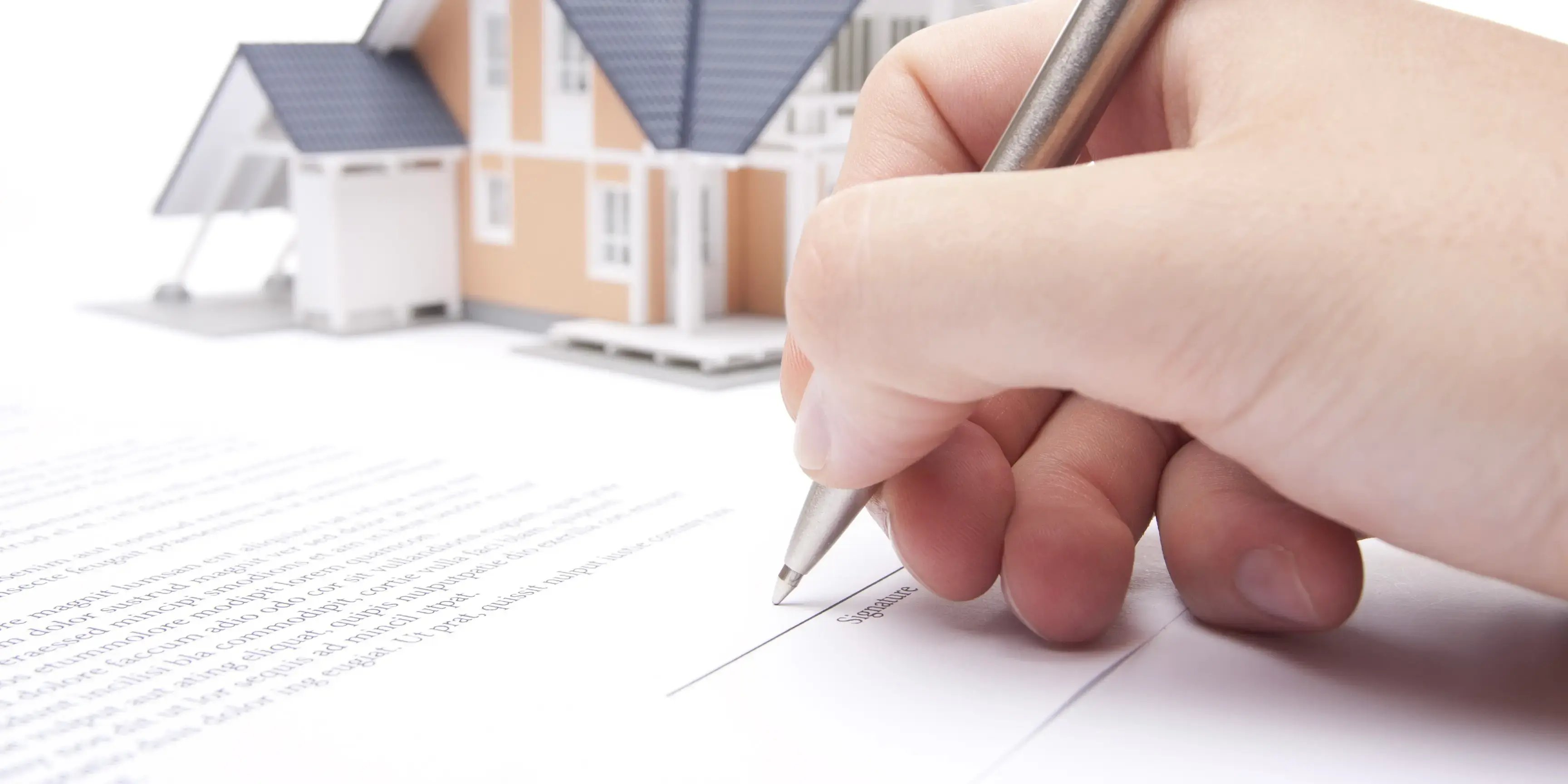 Persona firmando los documentos de un crédito hipotecario para comenzar a invertir en bines raíces