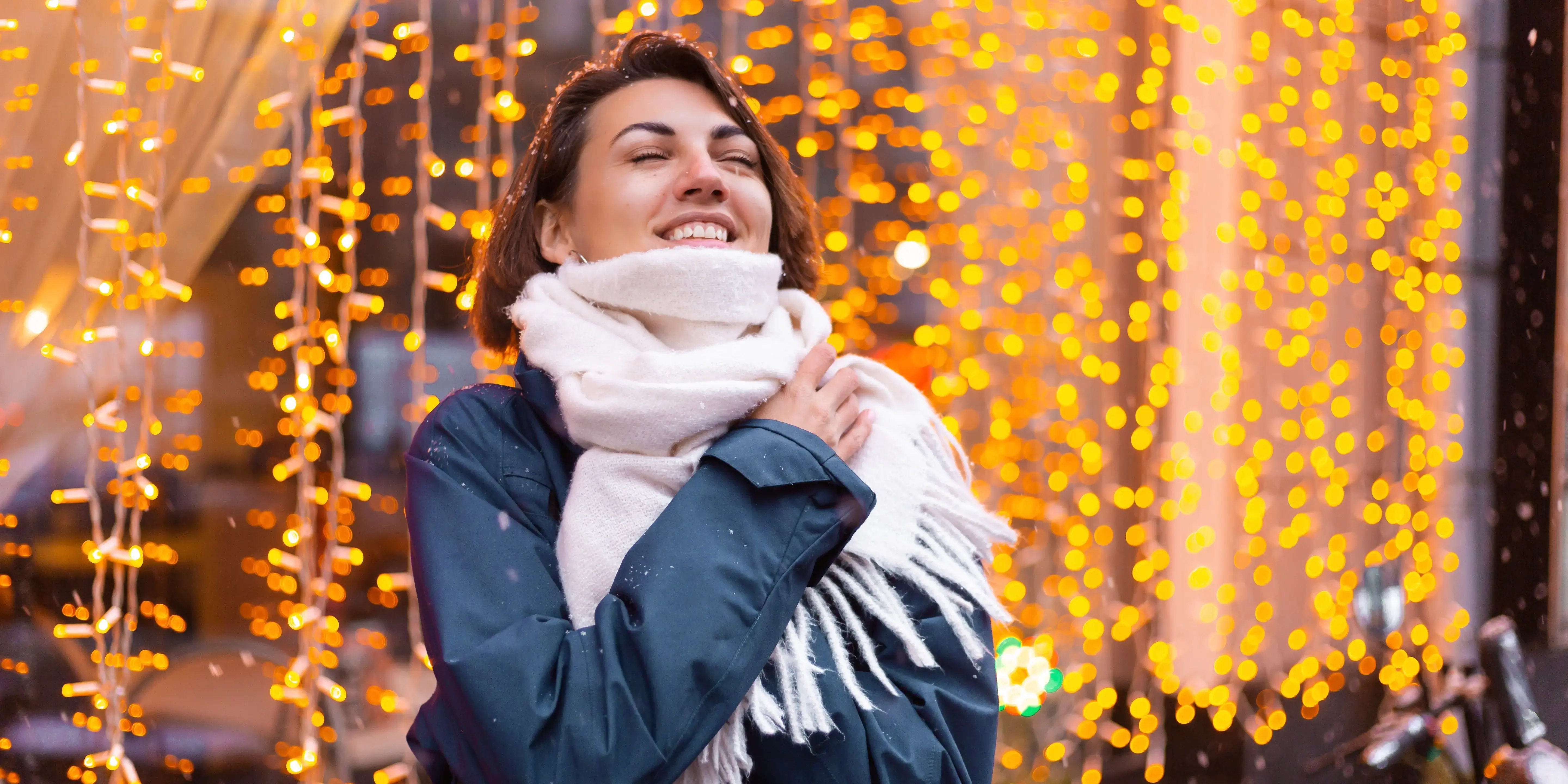 Mujer con bufanda y luces navideñas de fondo. Navidad en Hidalgo