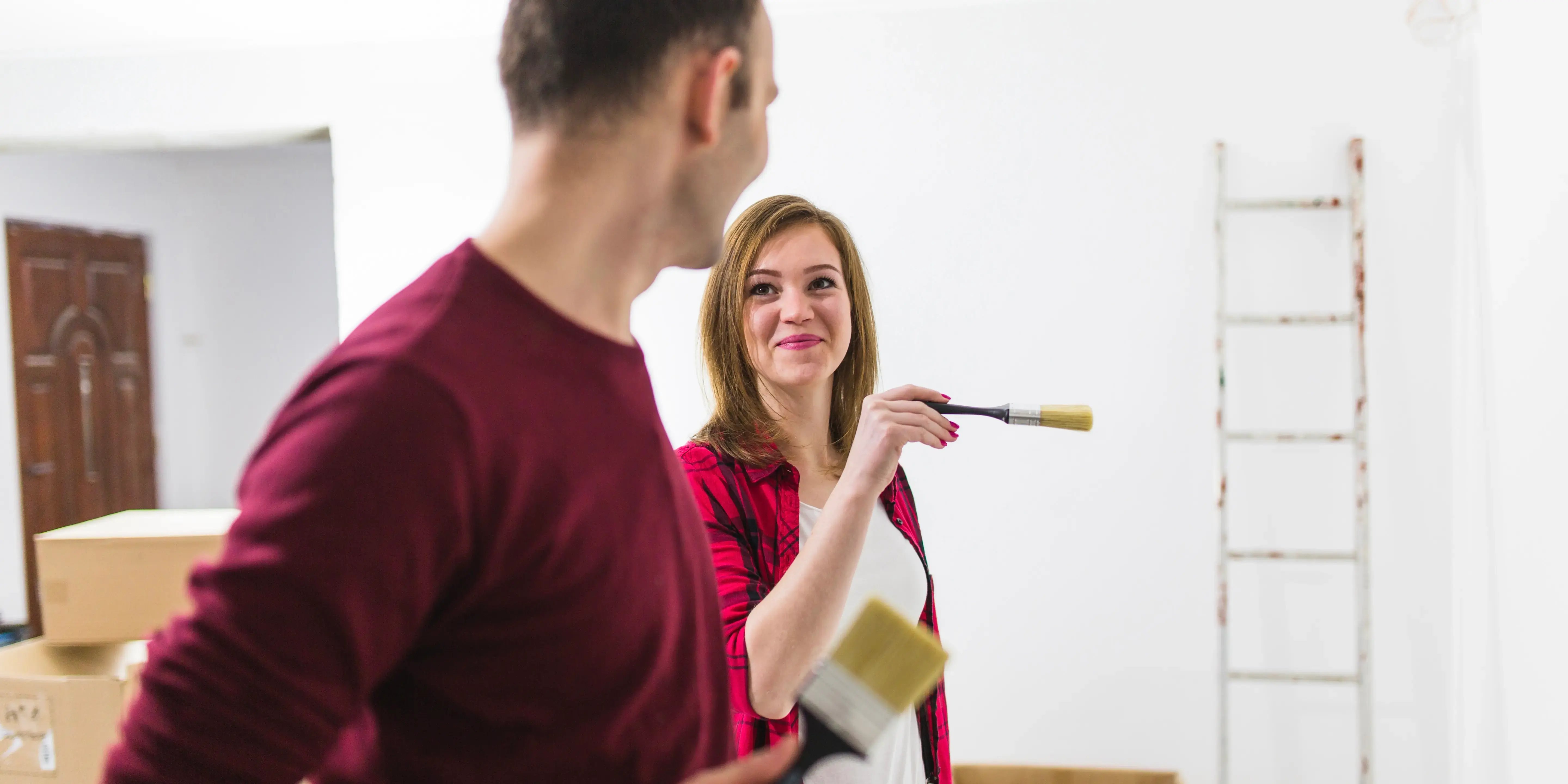 Pareja pintando casa. 7 Beneficios emocionales de ser propietario de una vivienda