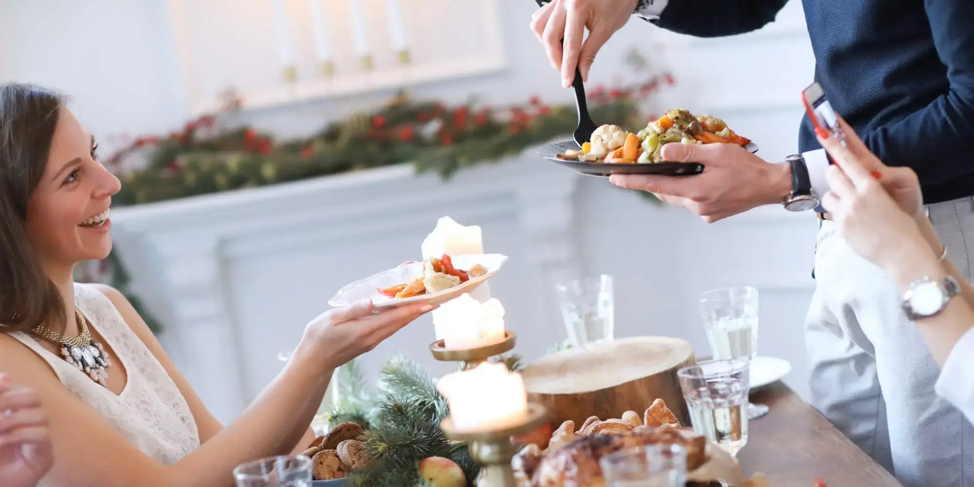 Personas en una mesa conviviendo y sirviéndose comida. Brunch navideño