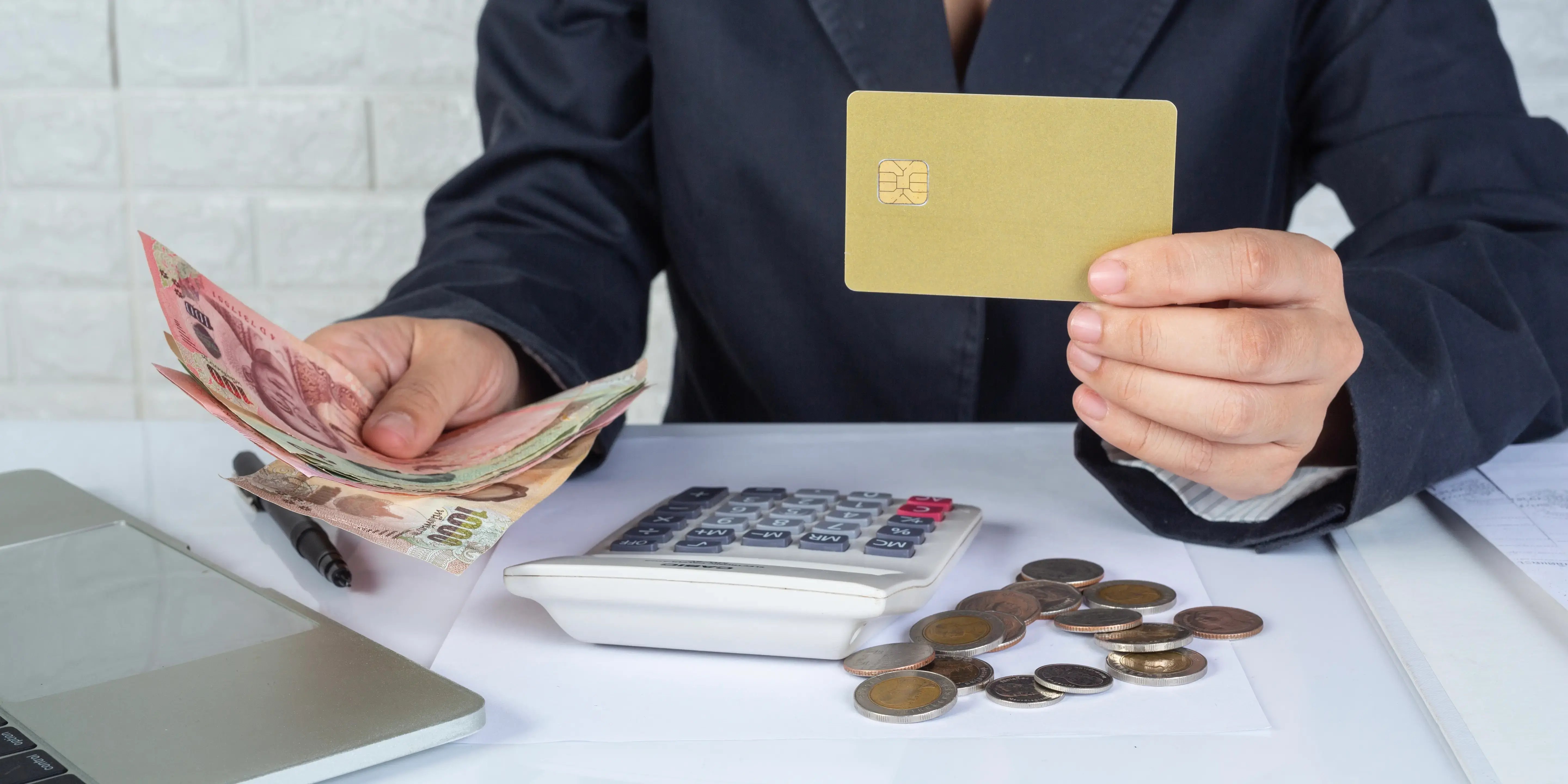 Manos con billetes y tarjeta de crédito. Funciones del dinero