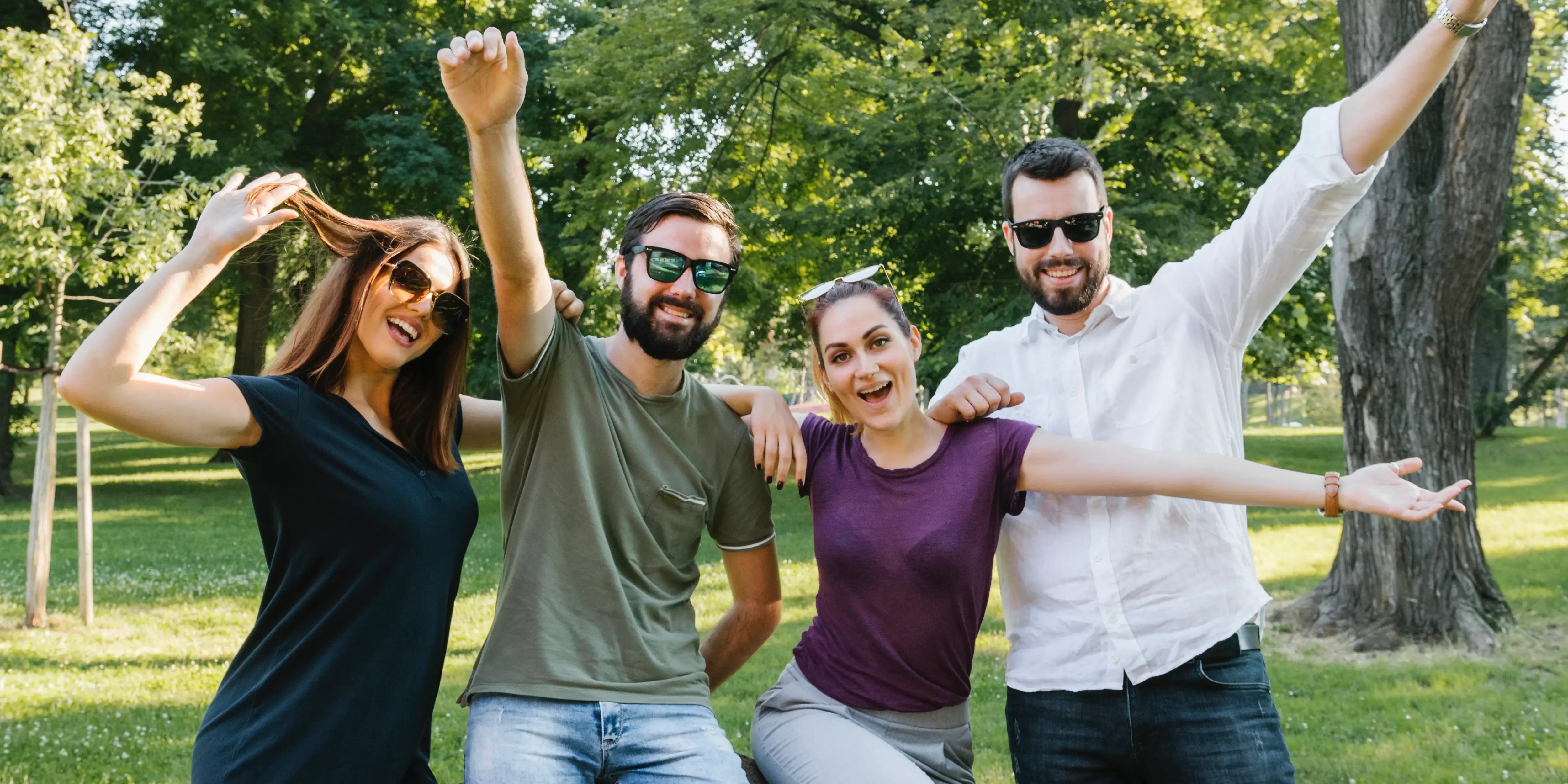 4 amigos felices levantando los brazos. Conectar con tus vecinos en San Valentín