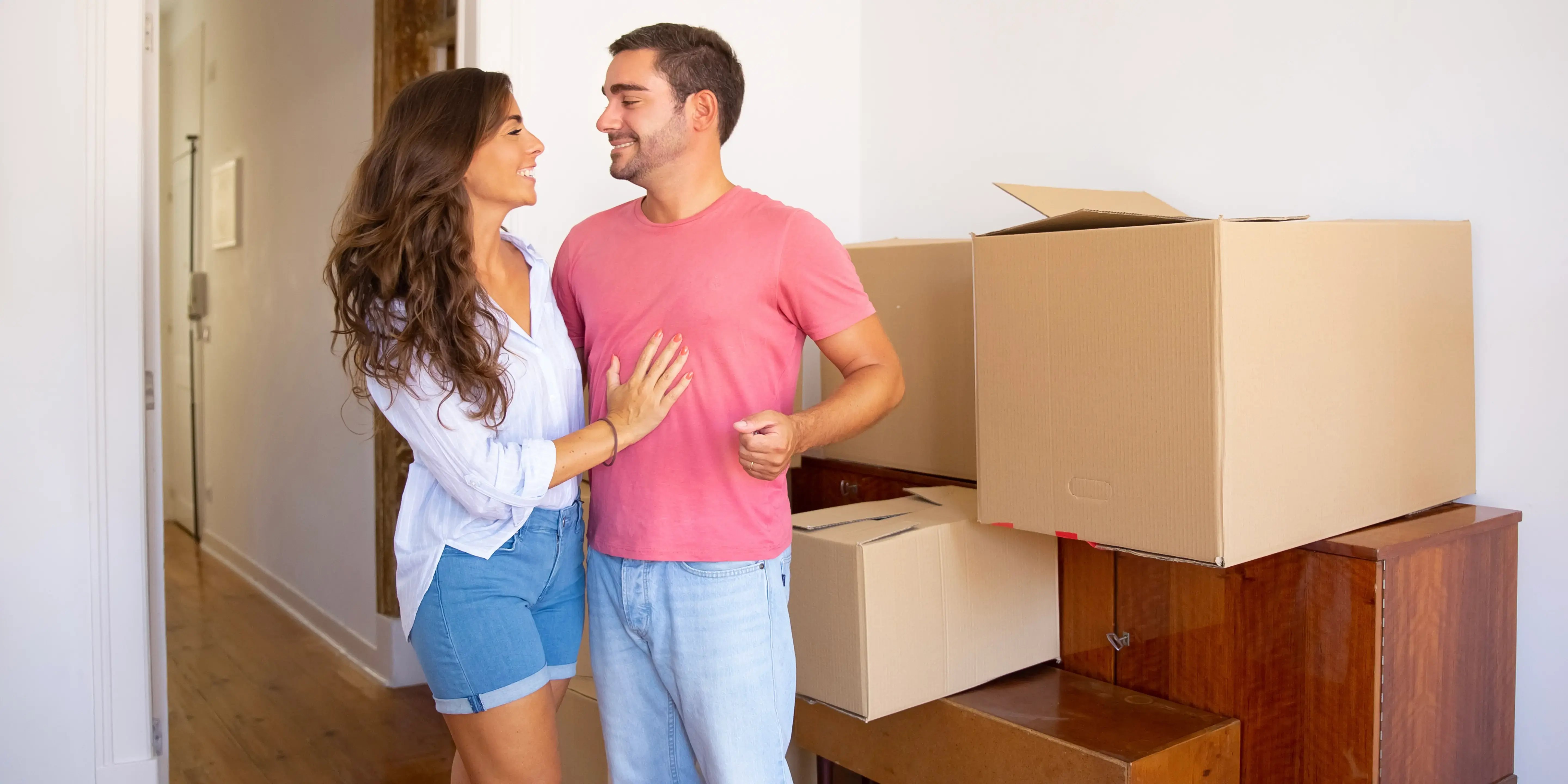 Pareja con cajas de mudanza. ¿Cómo comprar mi primera casa?