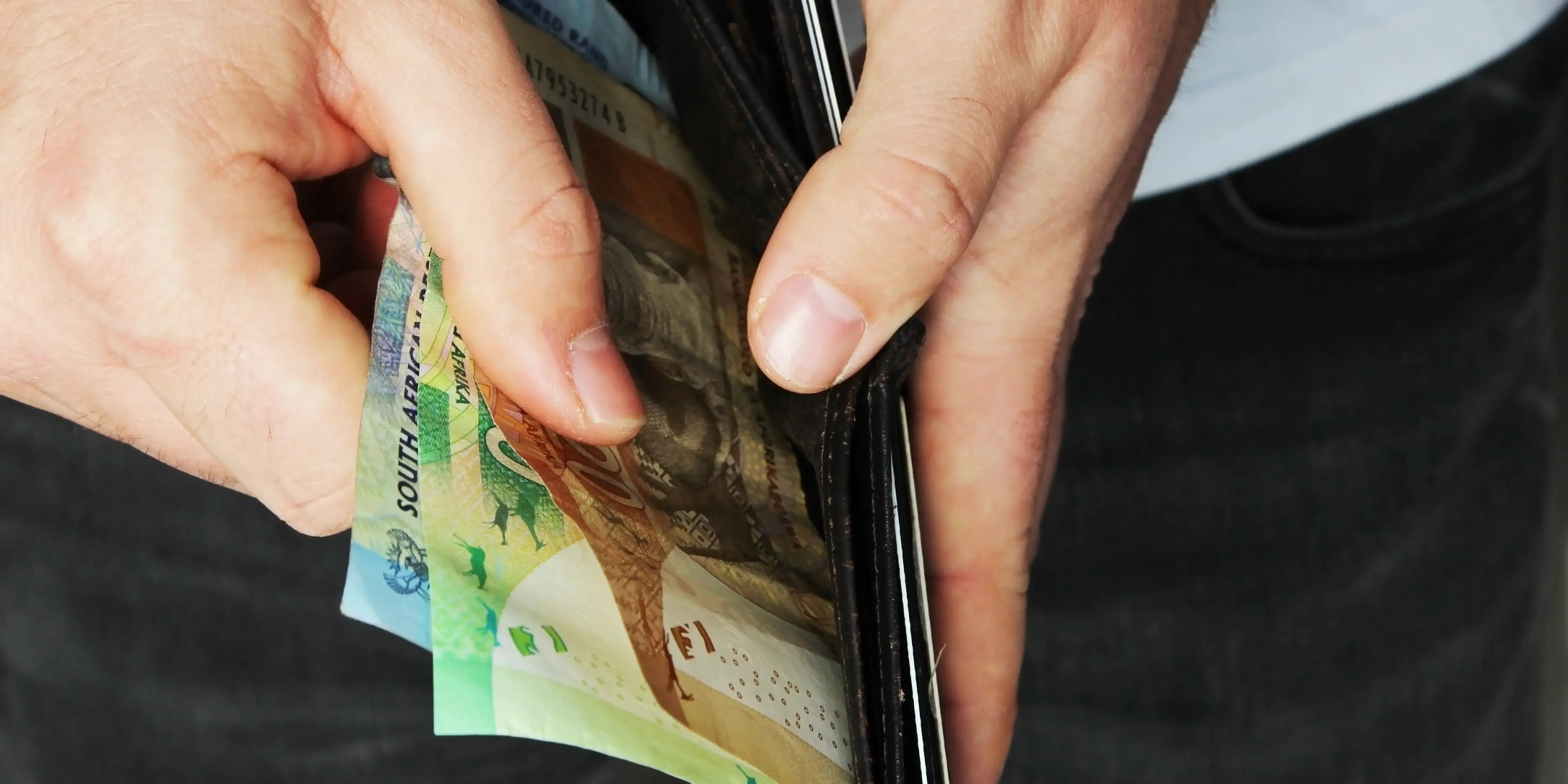Hombre viendo billetes en su cartera. Dismorfia del dinero