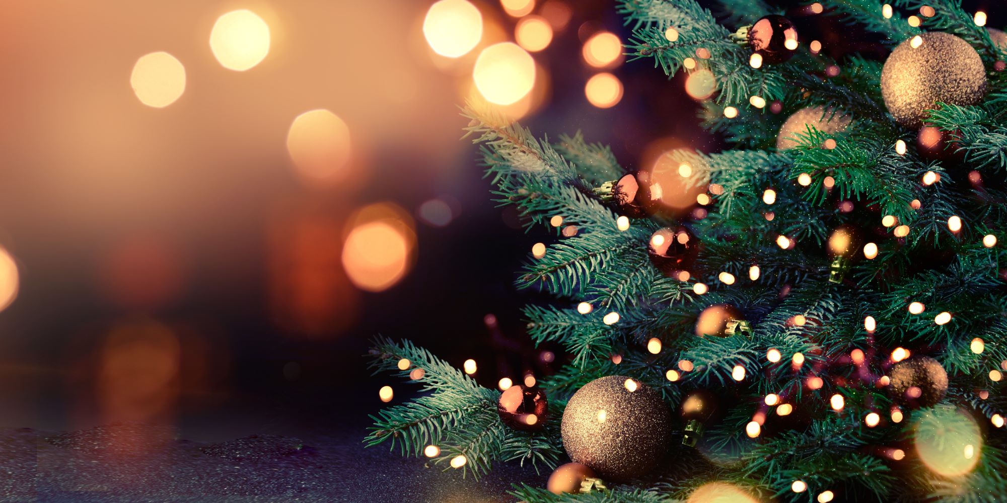 Árbol de navidad, con esferas y luces. De fondo, luces difuminadas.