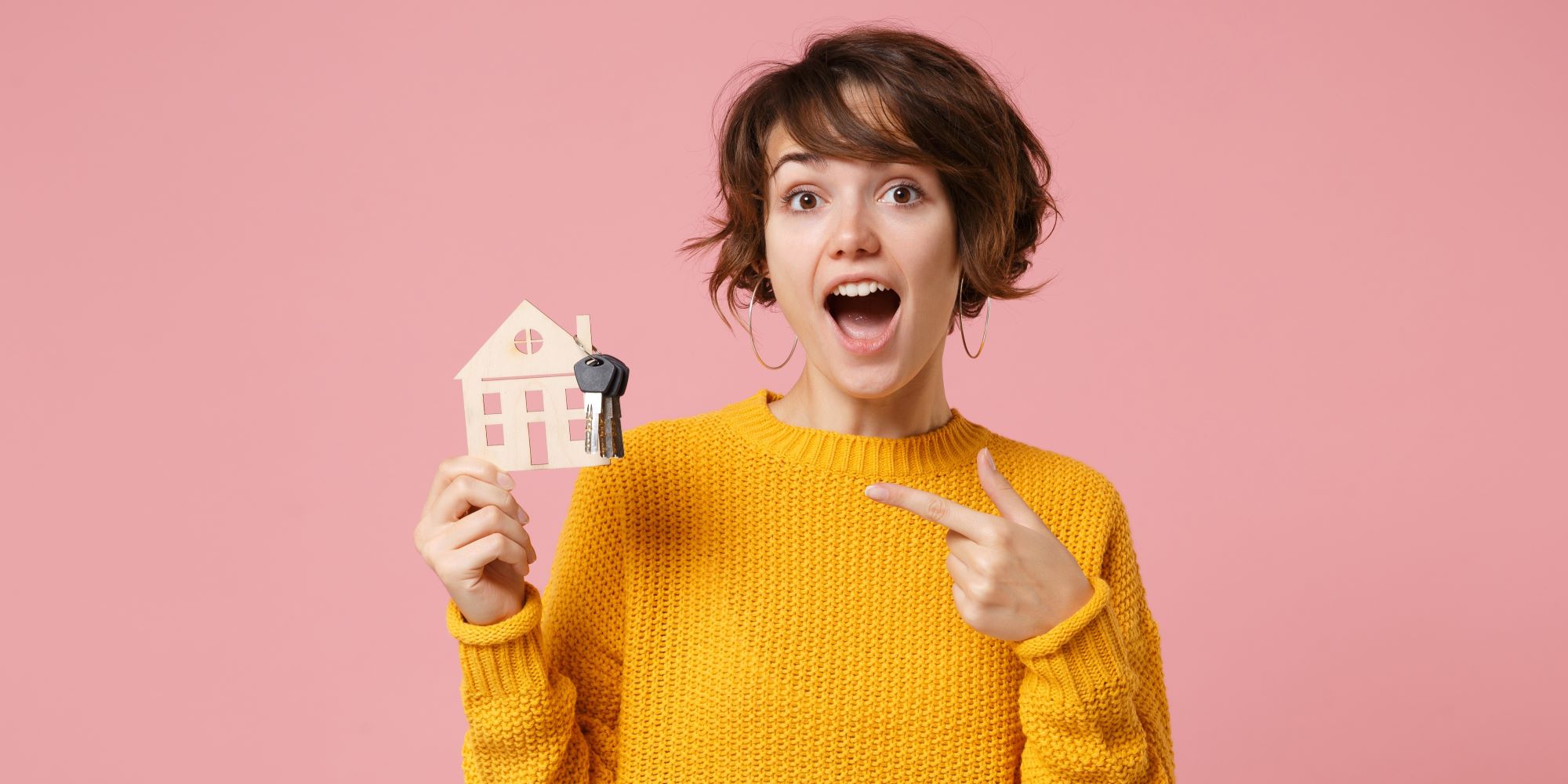Mujer está sorprendida por su nueva casa. Crédito hipotecario para jóvenes.