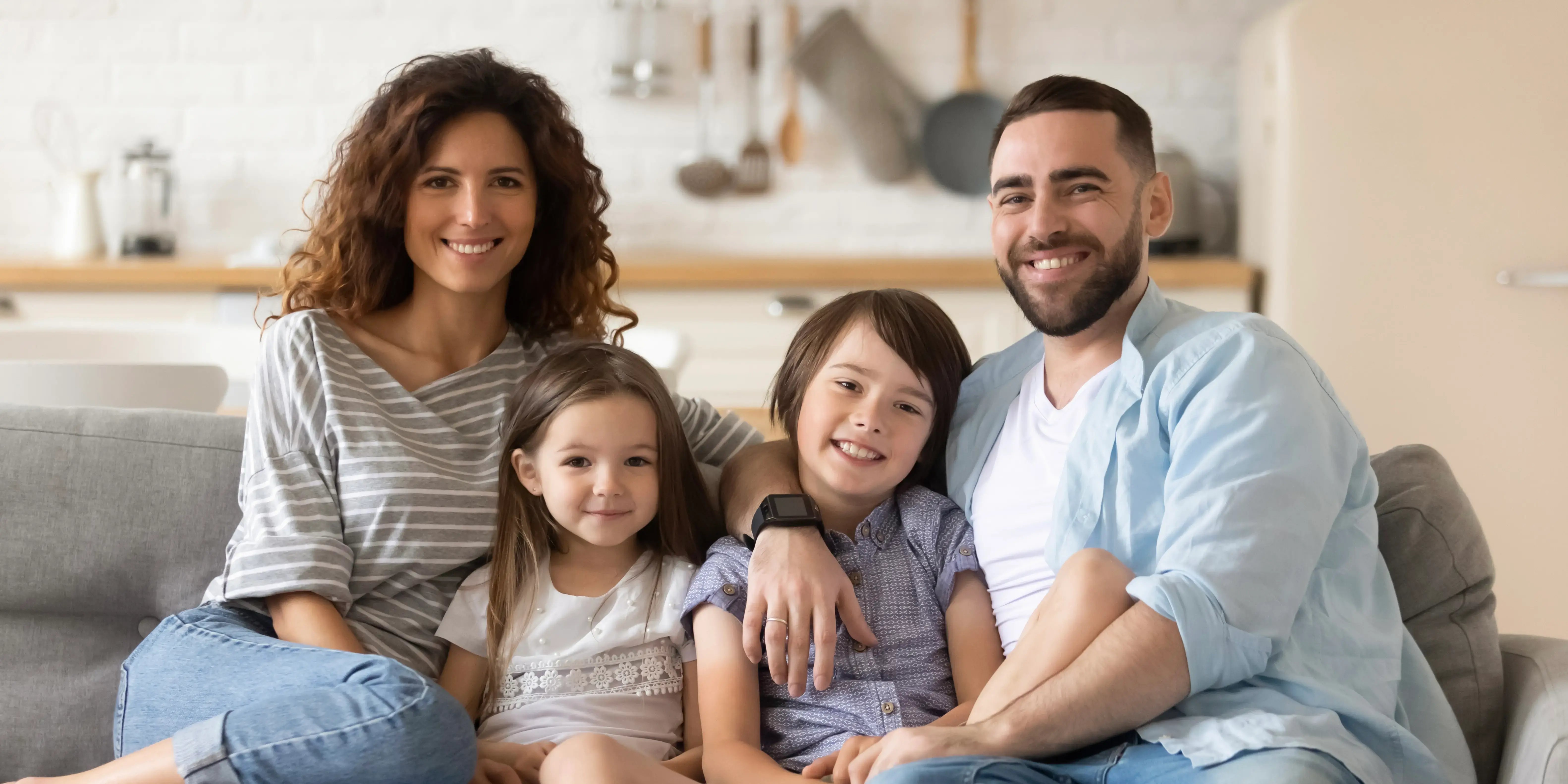 familia feliz sentada en un sillón. ¿qué es una casa dúplex?