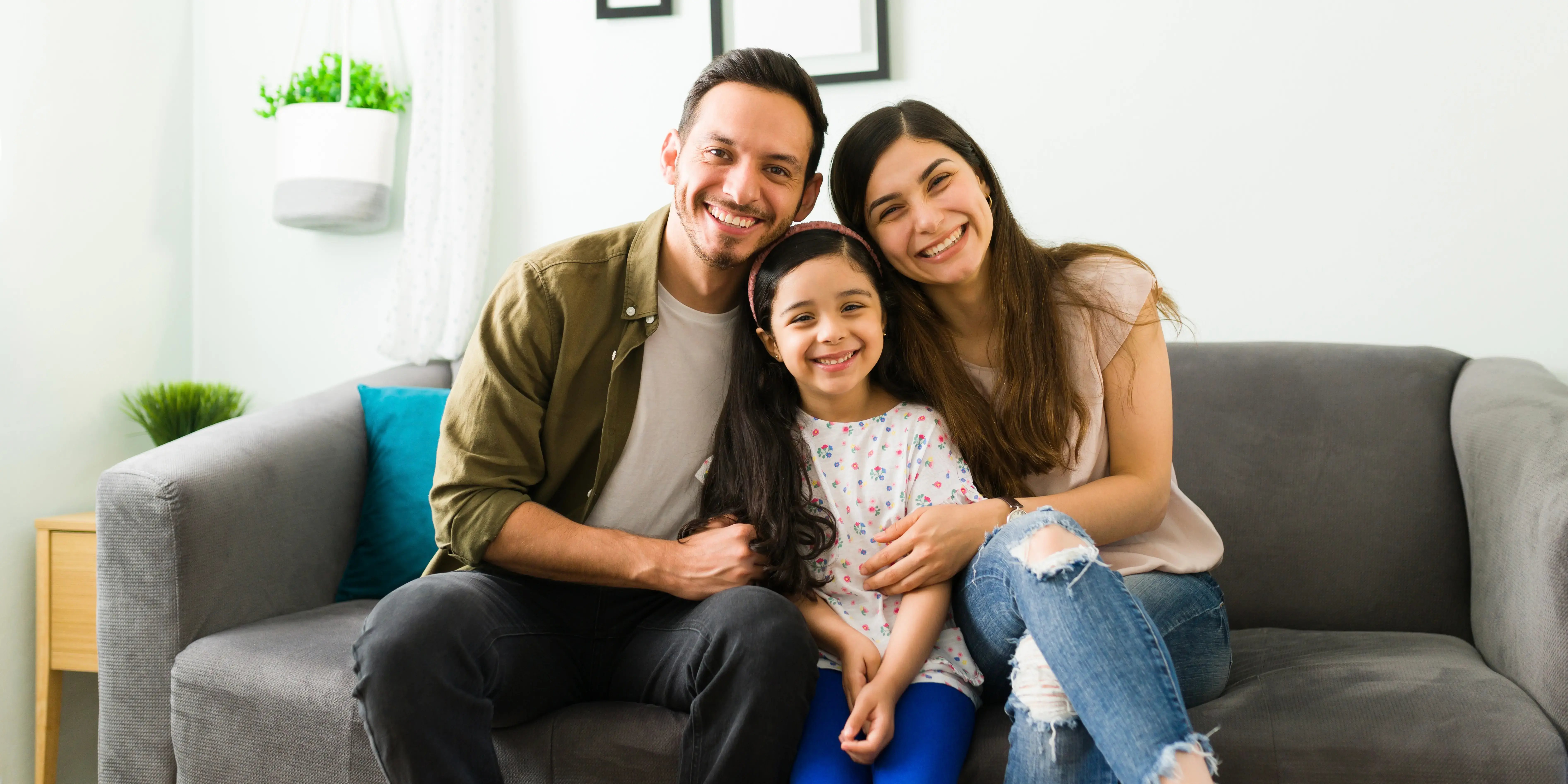 Familia feliz en sentada en sillón. Beneficios de vivir en casa duplex