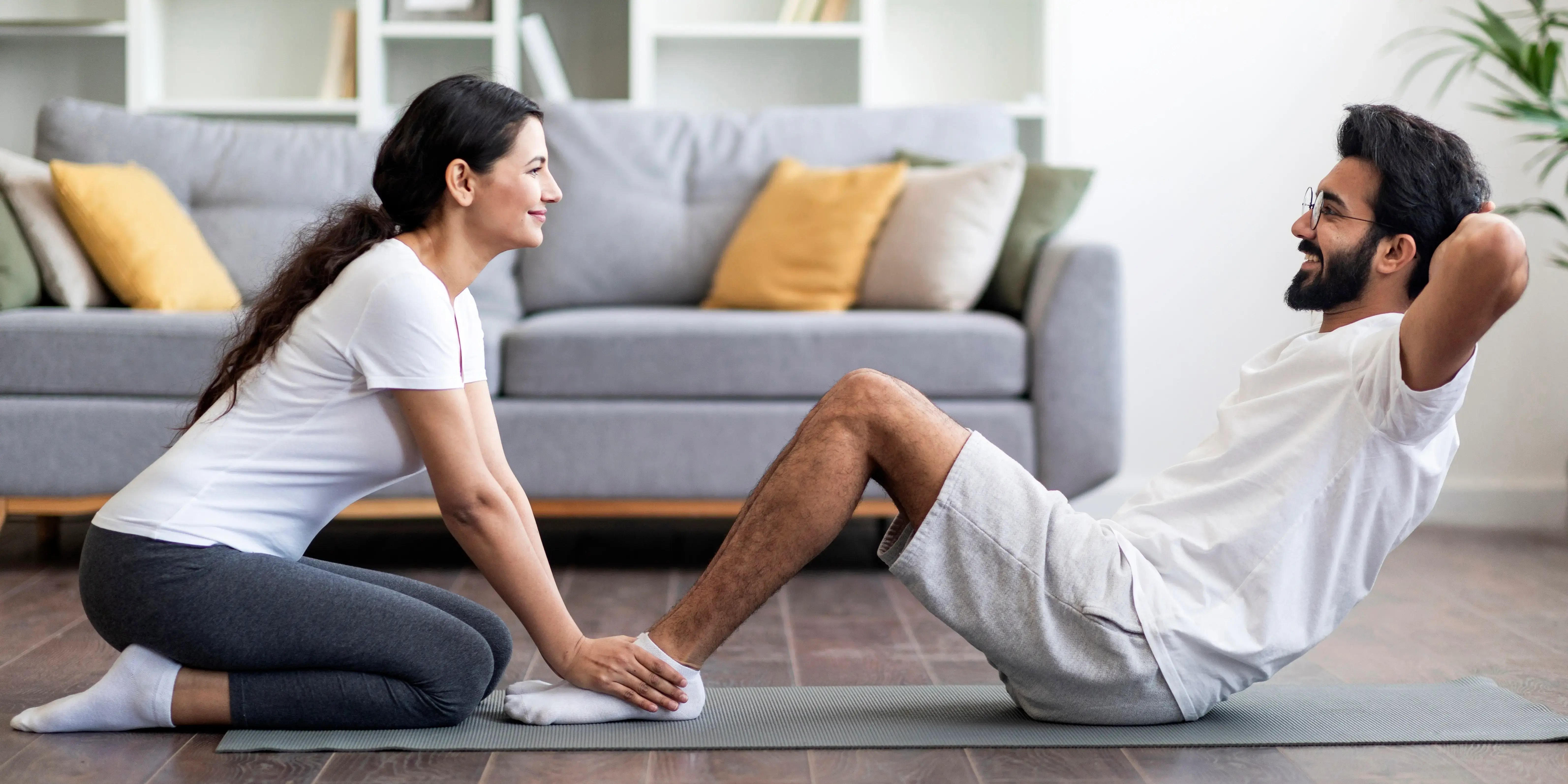 Pareja haciendo abdominales. ¿Qué es el sedentarismo?