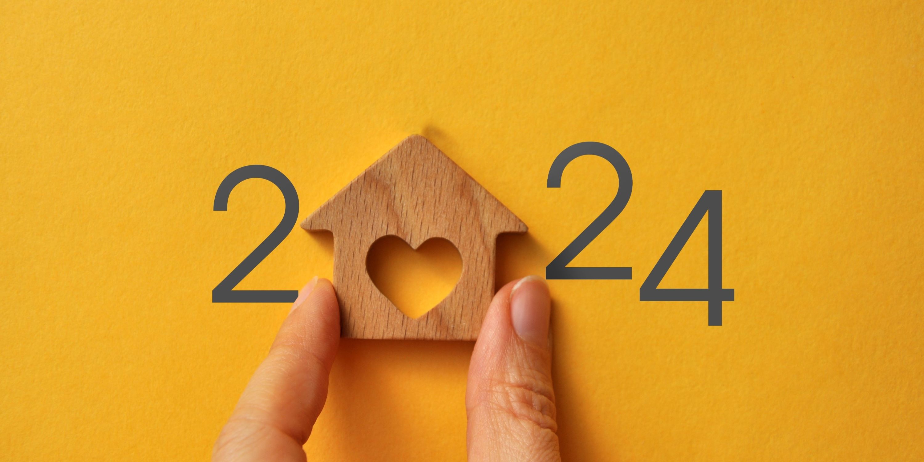 Oportunidades de inversión en el mercado inmobiliario este 2024. Una mano sujeta una casita de madera con un corazón en el centro.