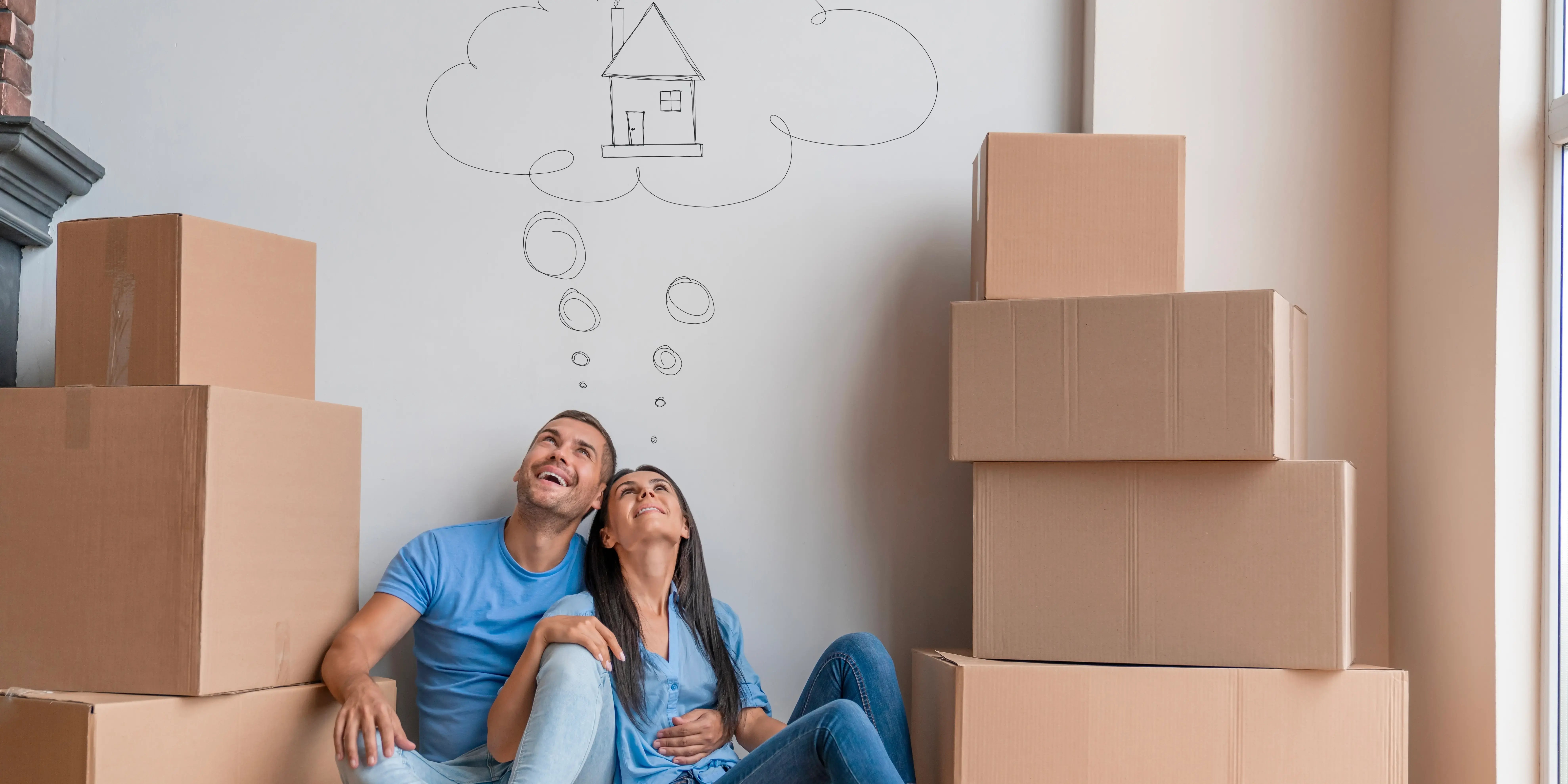 Pareja con cajas de mudanza imaginando su nueva casa. Deja de rentar