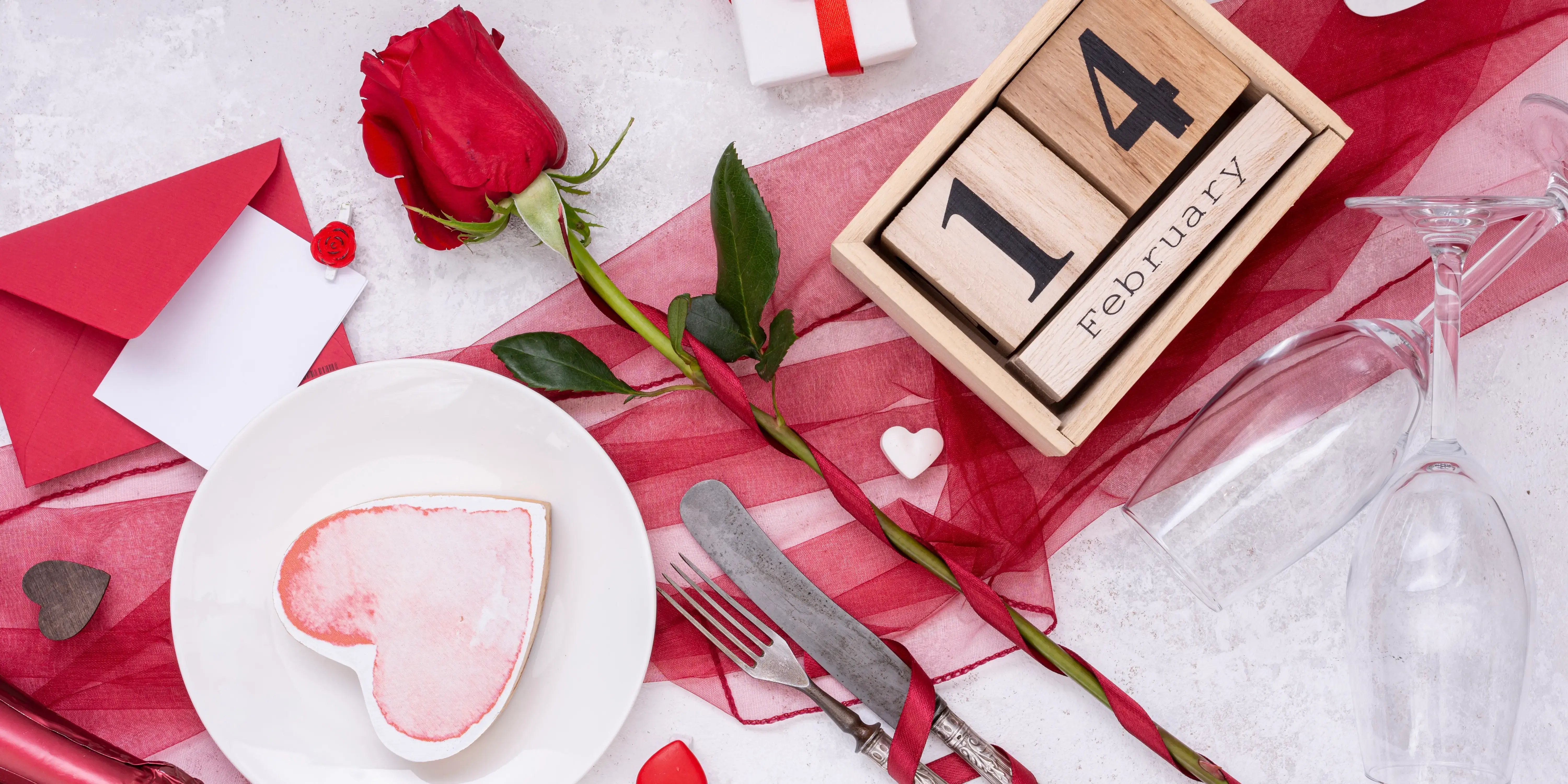 Mesa con plato, copas y una rosa roja. Ambientar tu casa este 14 de febrero