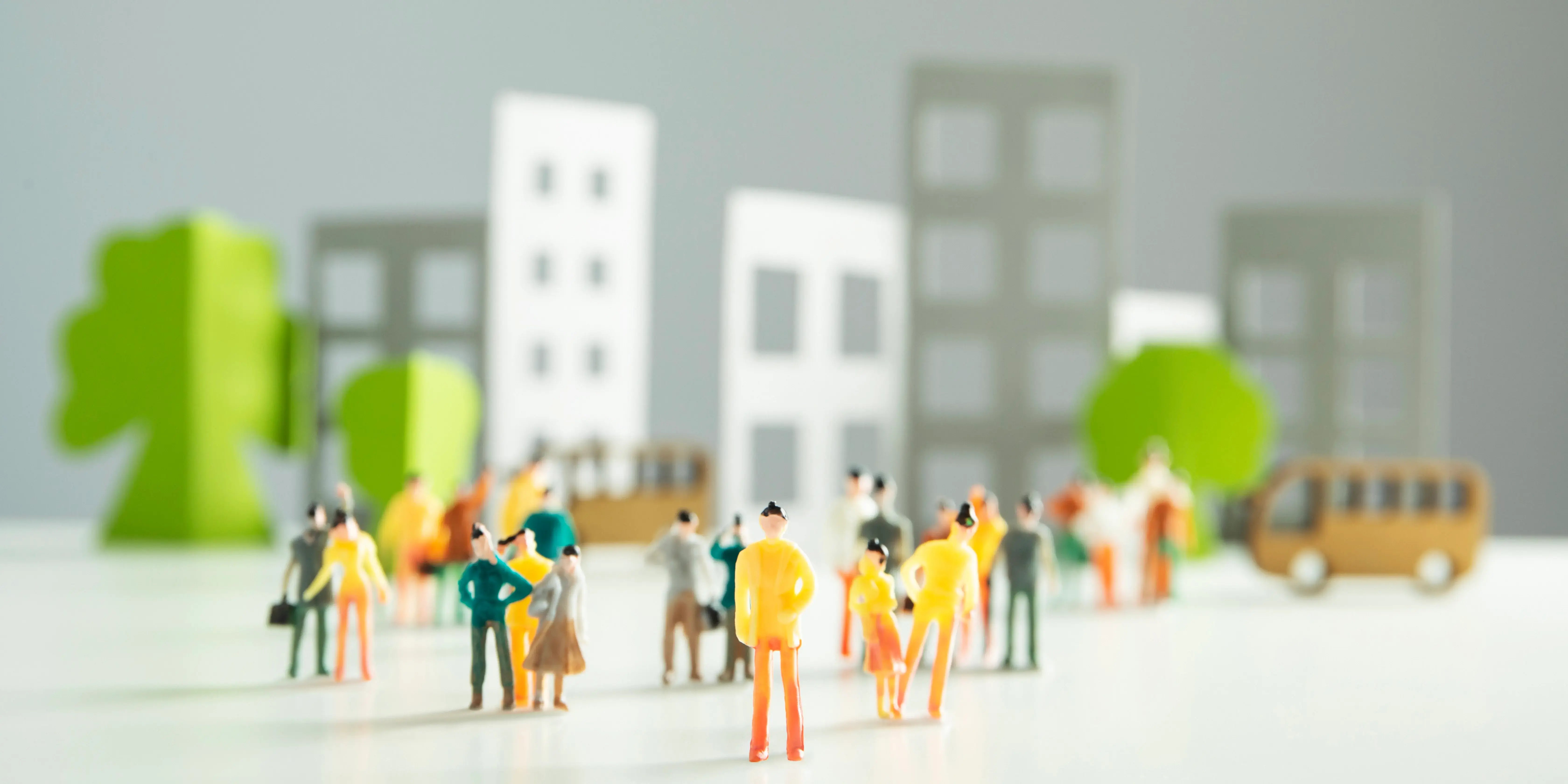 Maqueta de unos edificios con árboles alrededor y personas. Comunidad planificada