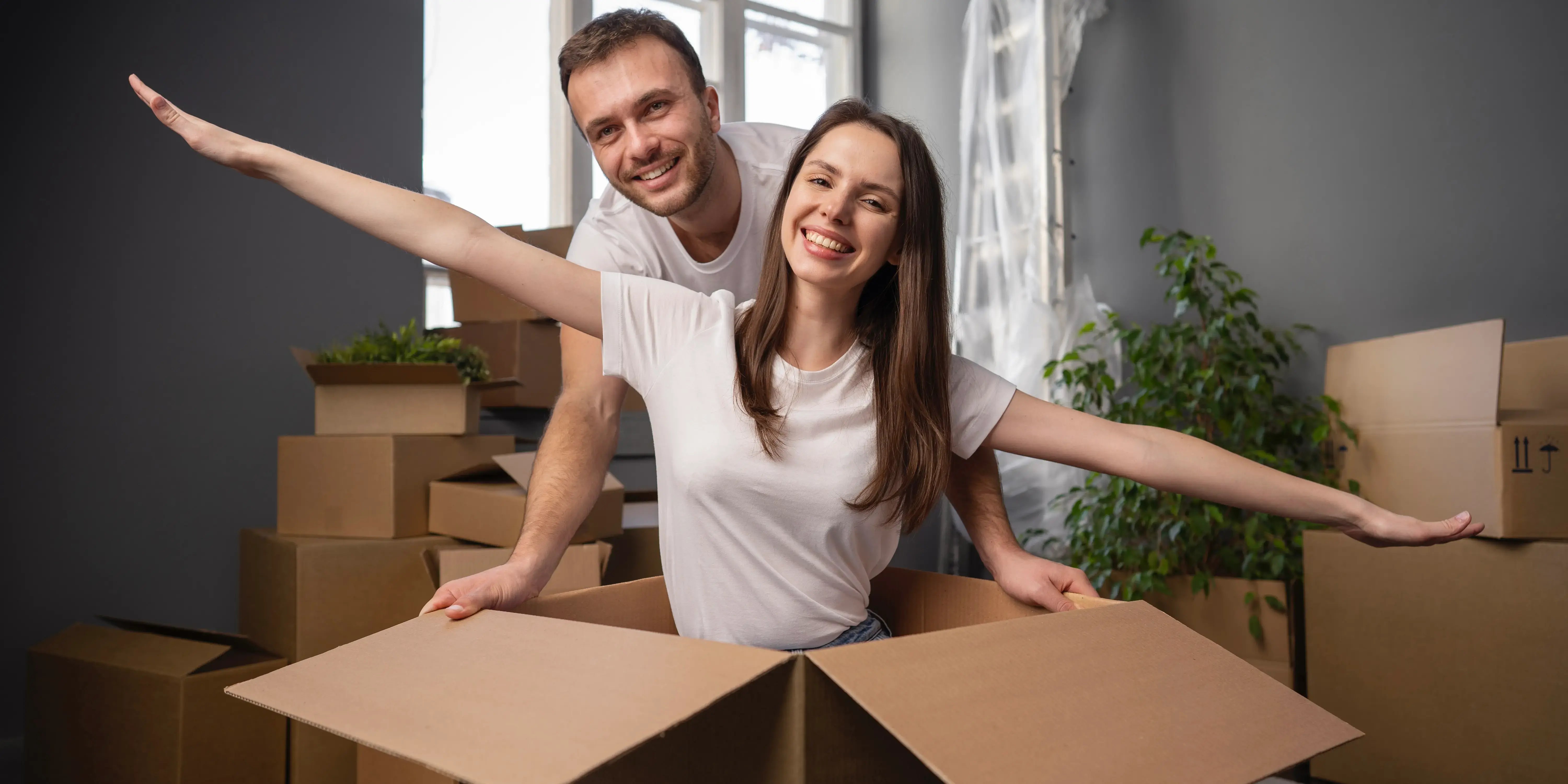 Pareja feliz con cajas de mudanza. 7 Beneficios emocionales de ser propietario de una vivienda