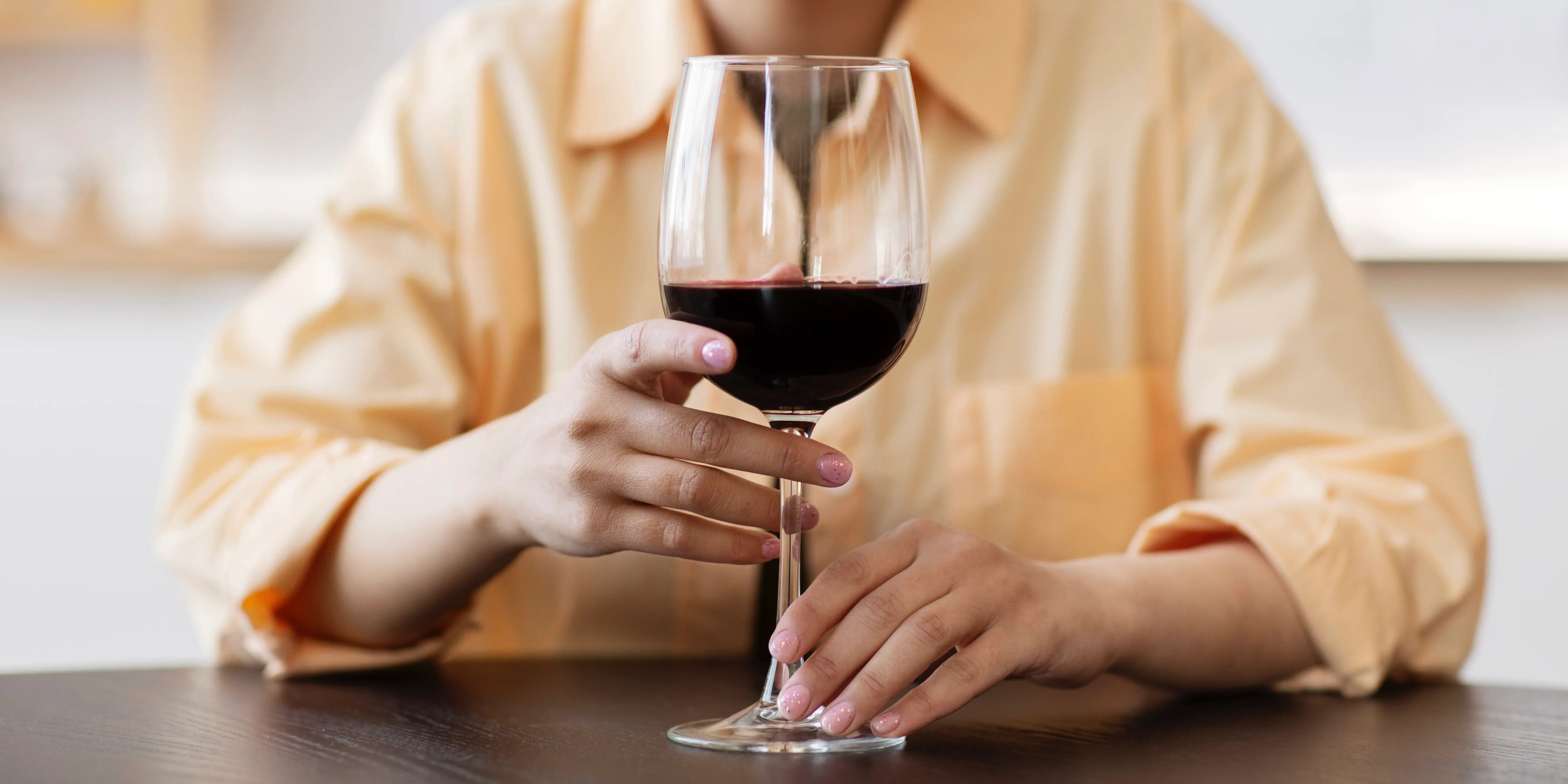 Mujer sosteniendo copa de vino. Tips para tomar vino